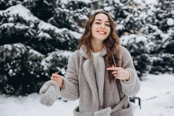 눈덮인 공원을 귀여운 소녀의 모습은 코트를 있으면서 행복하게 — 스톡 사진
