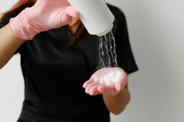 Siyah cüppeli, siyah eldivenli, kızıl saçlı, şekerleme üstadının eline pudra sürerken fotoğrafını çek.