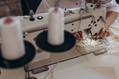 Uzun bir makine ve süs eşyası ile bir şeyler yapan birini görebiliyoruz. Beyaz bir gömlek giyiyor..
