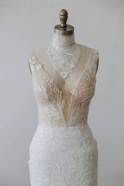 Mankenin üzerinde beyaz güzel bir elbise var. İlginç ve güzel bir süsü var..