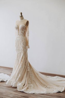 Odada duran güzel gri bir gelinlik var. Üzerinde bir sürü farklı ve yaratıcı desenler var..