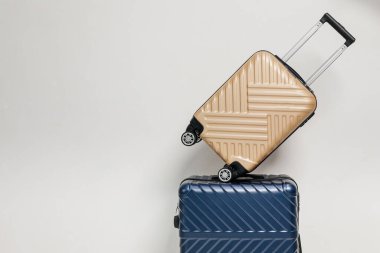 Seyahat çantalarının beyaz bir odada üstüste konduğu bir fotoğraf.