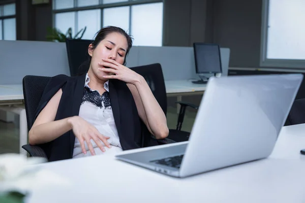 疲惫困倦的亚洲女人打呵欠在写字台工作 过度工作和剥夺睡眠的概念 — 图库照片