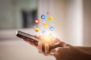 Akıllı telefon kullanıp emoji yollayan genç bir adam. Mobil akıllı telefon, emoji emoticon mesajı gönderiyor.