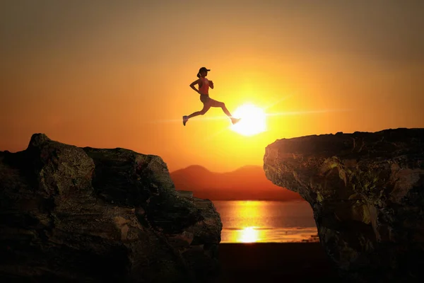 Silhouet Van Runner Springen Kloof Tussen Klif Met Avonds Zonsondergang — Stockfoto