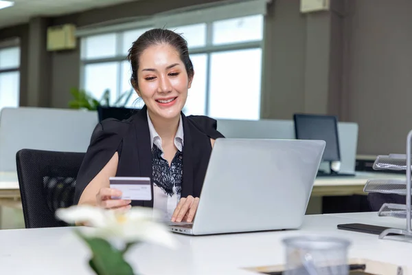 漂亮的年轻亚洲女人在办公室用笔记本电脑上网购物 用信用卡上网购物 — 图库照片