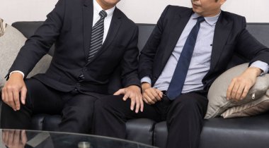 İşçi istismarı. Ofiste oturup cinsel tacize uğrayan erkek eline bakan neşeli, mutsuz bir işadamı..