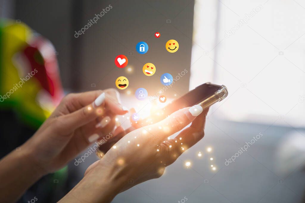 Young woman using smartphone sending emojis. Mobile smartphone sending text messages emoji emoticon.