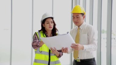 İki inşaat mühendisi. İş yerinde mühendislik nesneleri ve arka planda partnerler.