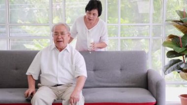 Gülümseyen Asyalı yaşlı çift evde süt içiyor..