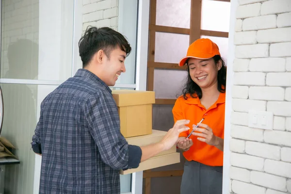 Deliverywoman Service Orange Uniform Handing Parcel Boxes Recipient Young Man — Stock Photo, Image