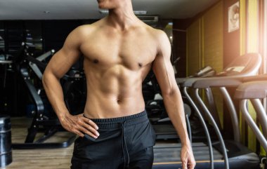 Yakışıklı kaslı adam poz veriyor ve kaslarını kasıyor..