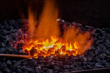 On the anvil, during the process of forge, on coal ignited in the forge, warming up to be wrought.