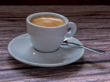 Kırsal arka planda kaşık olan bir fincan kahve..