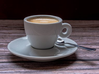 Kırsal arka planda kaşık olan bir fincan kahve. Tepesinde negatif boşluk var..