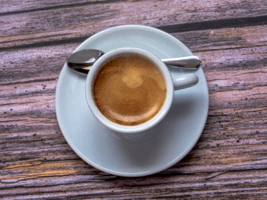 Kırsal arka planda kaşık olan bir fincan kahve..