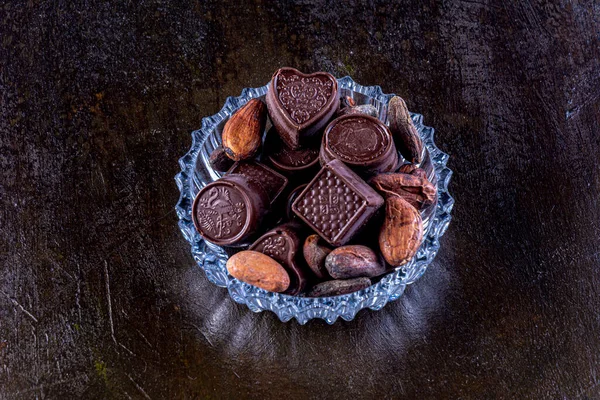 Chocolates Bandeja Vidrio Tallado Fotografiados Sobre Fondo Oscuro Con Granos — Foto de Stock