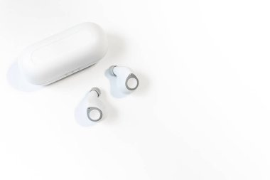 Ağ üzerinden bir telefona ya da akıllı telefona bağlı kablosuz kulaklıklar. Küçük kablosuz müzik taşınabilir akustik, beyaz kulaklıklar..