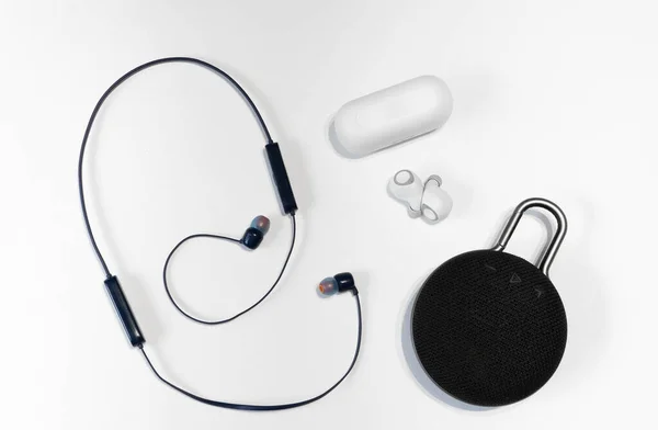 Wireless headphones connected to a phone or smartphone via a network, dark blue. Can be worn on the shoulders, around the neck. Small wireless music portable acoustics, white headphones.
