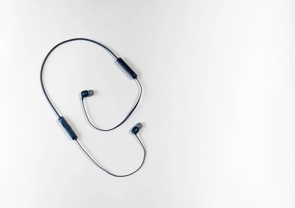 Ağ üzerinden bir telefona ya da akıllı telefona bağlı kablosuz kulaklıklar, koyu mavi. Omuzlarına, boynuna takılabilir. Küçük kablosuz müzik hoparlörü.