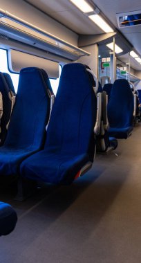 An empty carriage of a train, high-speed train or electric train with soft, separate seats.