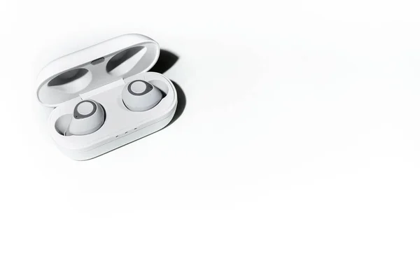 Ağ üzerinden bir telefona ya da akıllı telefona bağlı kablosuz kulaklıklar. Küçük kablosuz müzik taşınabilir akustik, beyaz kulaklıklar..