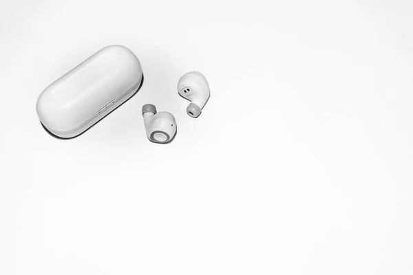 Ağ üzerinden bir telefona ya da akıllı telefona bağlı kablosuz kulaklıklar. Küçük kablosuz müzik taşınabilir akustik, beyaz kulaklıklar..