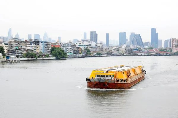 Cargo ship on the river with view of the city.