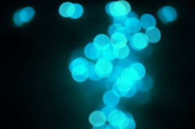 Gece karanlığında karanlığa bürünmüş renkli parlak mavi renkli bokeh noel ışıklarının soyut arkaplanı