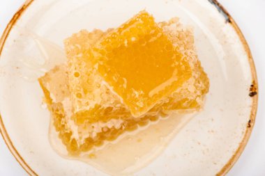 Beyaz arka planda izole edilmiş, üst manzaralı, taze kesilmiş birkaç altın taraklı bal dilimi yığınını kapat.