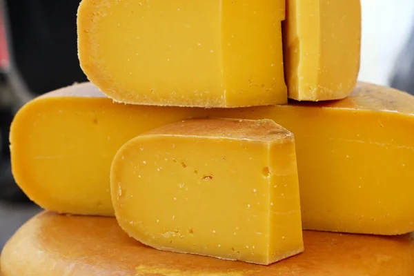 关闭切割切片和车轮硬成熟的黄色荷兰干酪 低角度视图 — 图库照片