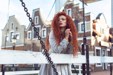 Şehirdeki kızıl saçlı kıvırcık kadın