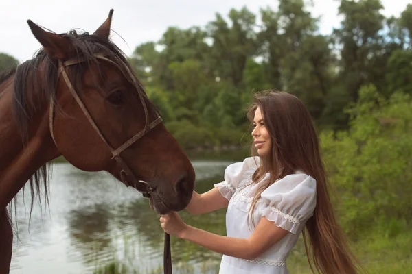 川の近くの馬と歩く — ストック写真