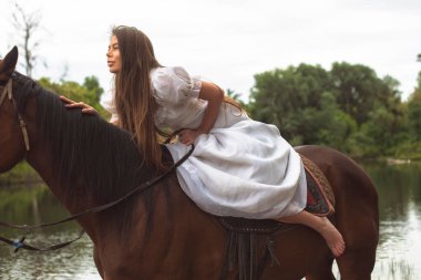 Nehir kıyısında bir atla yürü.