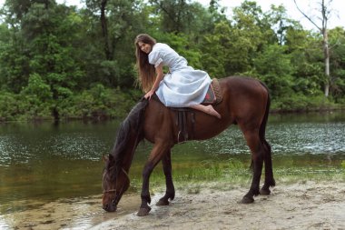 Nehir kıyısında bir atla yürü.