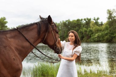 Nehir kıyısında bir atla yürü.