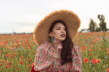 A young girl in a flowering poppy field