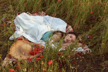 A young girl in a flowering poppy field