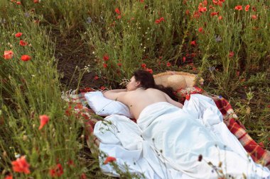 A young girl in a flowering poppy field