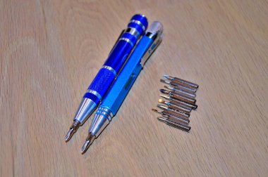 Arkaplan olarak ahşap bir masada tornavida......