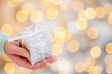 Yetişkin adam elinde Advent bayramı hediyesi olan bir kutu tutuyor. Mutlu yıllar ve mutlu Noeller.