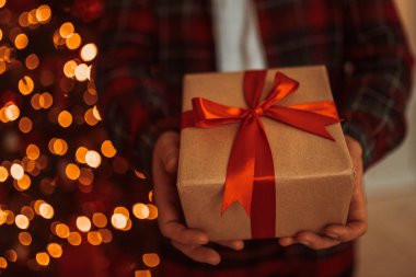 Yetişkin adam elinde Advent bayramı hediyesi olan bir kutu tutuyor. Mutlu yıllar ve mutlu Noeller.
