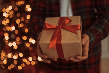 Yetişkin adam elinde Advent bayramı hediyesi olan bir kutu tutuyor. Mutlu yıllar ve mutlu Noeller.