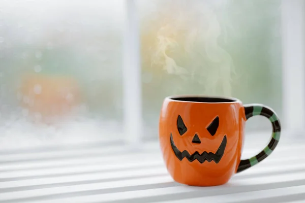 cup of coffee and pumpkin face on it
