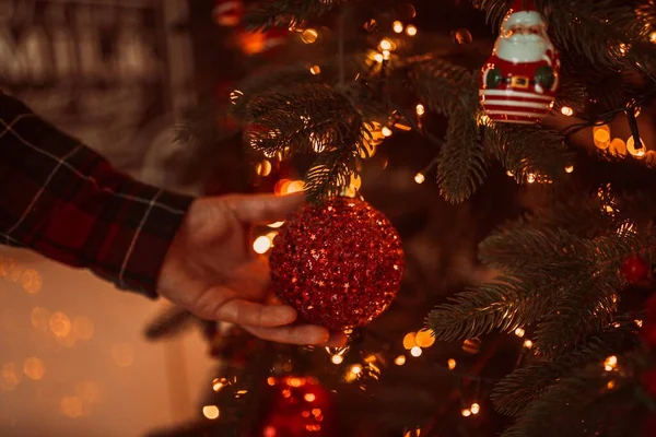 Hand Hand Schmückt Ein Mann Einen Festlichen Weihnachtsbaum Mit Kugeln — Stockfoto