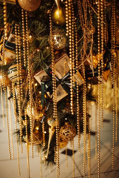 Şen Noel 'i kutluyoruz kış tatili altın parıltısı parıltı Coco Chanel kozmetik markası ters süslü ağaç süslemeleri sunar 