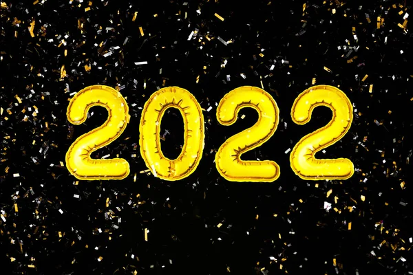 2022 Feliz Año Nuevo números de texto, confeti sobre fondo negro. Decoración de saludo fiesta de Navidad — Foto de Stock