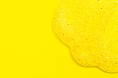 Kozmetik serumu ya da sarı arka planda fırça örneği. Parçacık pankartlı şeffaf sıvı jel damlası.