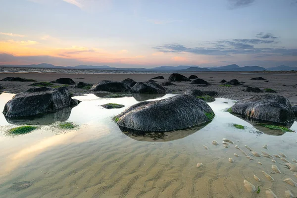 Harlech Sahili 'nde gün batımı. Kuzey Galler' in Gwynedd ilçesinde bir sahil beldesi. Snowdonia Dağları 'na bakıyor