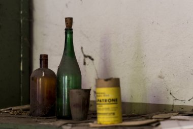 Terk edilmiş bir yerde terk edilmiş şişelerin resmi.